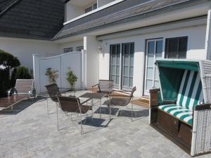 un patio con tavolo, sedie e piscina di Ferienwohnung für 4 Personen ca 111 qm in Munkmarsch, Nordfriesische Inseln Sylt a Munkmarsch
