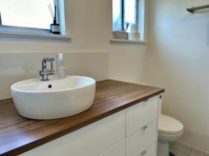 een badkamer met een witte wastafel en een toilet bij The Old Bakery Guesthouse, Harden in Harden