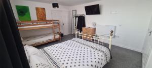 a bedroom with two bunk beds and a tv at The Hive Great Yarmouth in Great Yarmouth