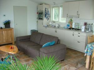 ein Wohnzimmer mit Couch und Küche in der Unterkunft Hausboot Schiff für 4 Personen ca 85 m in Oudega, Friesland Küste von Friesland in Oudega