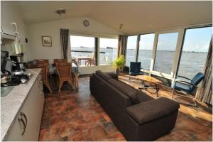 ein Wohnzimmer mit Couch und Blick aufs Meer in der Unterkunft Hausboot Schiff für 4 Personen ca 85 m in Oudega, Friesland Küste von Friesland in Oudega + 14 Fotos