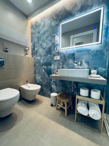 a bathroom with a sink and a toilet and a mirror at Lina suites & rooms in La Spezia