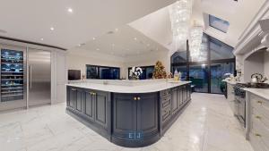 a large kitchen with a large island in the middle at Grand London suburban mansion in Buckhurst Hill
