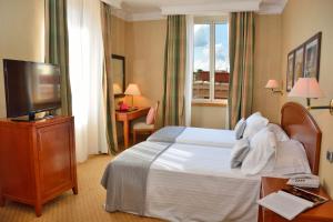 a hotel room with a bed and a flat screen tv at LH Hotel Lloyd Roma in Rome