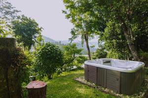 a bath tub sitting in the grass next to a tree at Muangkham Cabin in Chiang Mai