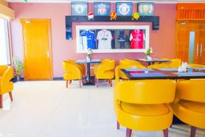 a restaurant with yellow chairs and tables and a baseball jersey at Palette Royal Reflections Hotel and Spa Dubai in Dubai