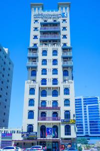 a tall white building with a sign on it at Palette Royal Reflections Hotel and Spa Dubai in Dubai