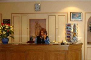 a woman taking a picture of herself in a mirror at Hôtel des Pyrénées - Entre Bastille et Nation in Paris