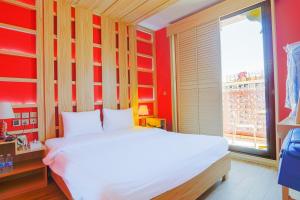 ein Schlafzimmer mit einem weißen Bett und einem großen Fenster in der Unterkunft Palette Royal Reflections Hotel and Spa Dubai in Dubai