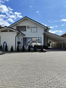 a white house with a driveway at Black&White House in Ocna-Mureşului