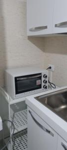 un horno microondas en la parte superior de una barra de cocina en Sister's home, en Iglesias