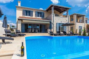 een villa met een zwembad en een huis bij Ferienhaus mit Privatpool für 8 Personen ca 180 qm in Deklići, Istrien Istrische Riviera in Kaštelir