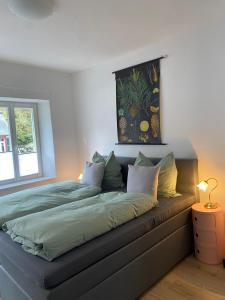 a bed in a bedroom with a picture on the wall at Hüftgold schlafen & wohnen in Monschau