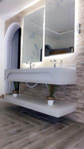 a bathroom with a white sink and a mirror at Retal Hotel Apartments in Taif