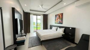1 dormitorio con 1 cama y TV de pantalla plana en Sunrise ocean villa, en Phuket