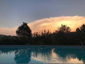 una piscina con tramonto sullo sfondo di Ferienhaus mit Privatpool für 6 Personen ca 400 qm in Morra, Trasimenischer See a Città di Castello