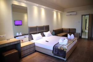 1 dormitorio con 1 cama grande con almohadas blancas en Mayur Residency Hotel en Guwahati