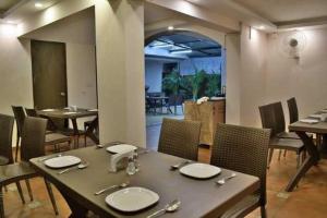a dining room with a table and chairs and a room with a dining room at Aveeno Resort with Swimming Pool Near Calangute & Baga in Goa