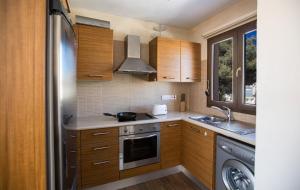 a kitchen with wooden cabinets and a stainless steel refrigerator at Ferienwohnung für 5 Personen ca 1 qm in Agia Napa, Südküste von Zypern in Ayia Napa