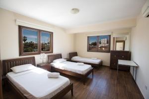 a room with two beds and two windows at Ferienwohnung für 5 Personen ca 1 qm in Agia Napa, Südküste von Zypern in Ayia Napa