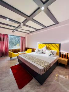 a bedroom with a large bed and a red rug at Hotel Apple Flower in Manāli