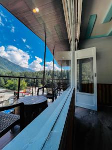 a balcony with a view of the mountains at Hotel Apple Flower in Manāli