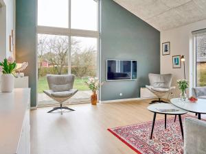 a living room with two chairs and a tv at Holiday home Nexø IX in Neksø