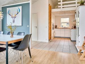 a kitchen and dining room with a table and chairs at Holiday home Nexø IX in Neksø