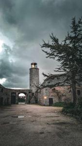 un faro sentado en la parte superior de un edificio de piedra en Les Chambres du Château du Rozel, en Le Rozel