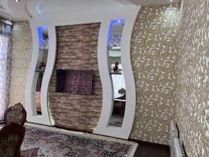 um quarto com três espelhos numa parede de tijolos em Almotrudiy apartament em Samarkand