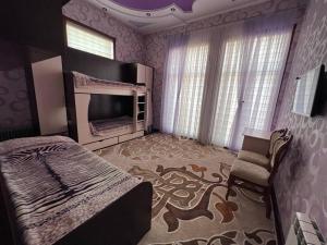 Almotrudiy apartament في سمرقند: غرفة نوم بسرير وتلفزيون في غرفة