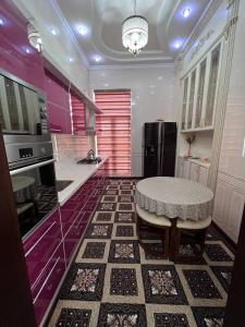 uma cozinha com uma mesa e um frigorífico preto em Almotrudiy apartament em Samarkand