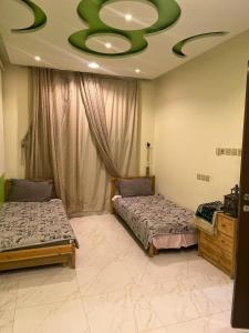 a bedroom with two beds and a green ceiling at سفانه in Unayzah