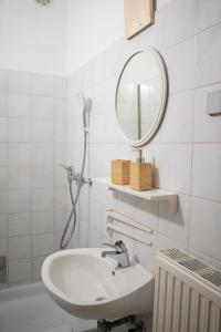 Baño blanco con lavabo y espejo en Apartmaji PAJTLER, en Zgornja Kungota