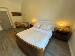 a bedroom with a large bed with two tables and two lamps at La Dimora di B.Cairoli in Ovada