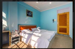 ein blaues Schlafzimmer mit einem Bett mit einem Schwan darauf in der Unterkunft The Kannaz in Srinagar
