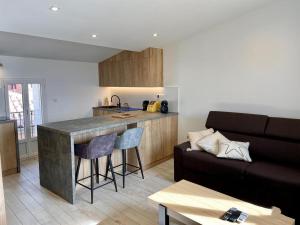 a kitchen and a living room with a couch at L’escale enchantée in Bouzigues