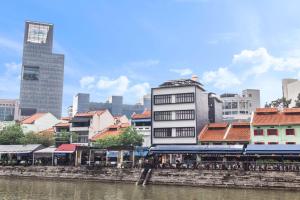 a city with buildings and a river with a train at Heritage Collection on Boat Quay - South Bridge Wing in Singapore