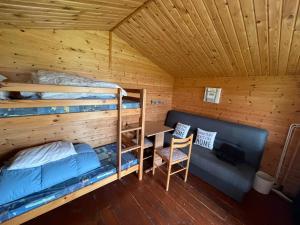 a room with bunk beds and a desk in a cabin at Himmerland camping & Feriecenter in Års