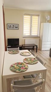 a kitchen with three plates on a table at Apartament Jola in Polanica-Zdrój