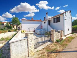 een wit huis met een hek ervoor bij Ferienhaus mit Privatpool für 4 Personen ca 40 qm in Pajkovići, Istrien Binnenland von Istrien in Pajkovići