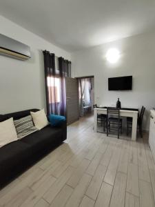 ein Wohnzimmer mit einem schwarzen Sofa und einem Tisch in der Unterkunft Casa vacanze I GIRASOLI -R4042- in Sorso