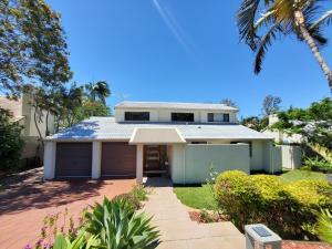 a house with a palm tree in front of it at Serene Lakefront Villa with Private Pool 