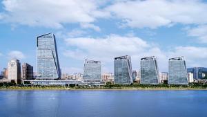 eine Gruppe hoher Gebäude neben einem Wasserkörper in der Unterkunft InterContinental Zhuhai by IHG in Zhuhai