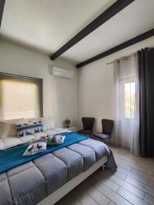 1 Schlafzimmer mit einem großen Bett und 2 Stühlen in der Unterkunft Casa vacanze I GIRASOLI -R4042- in Sorso