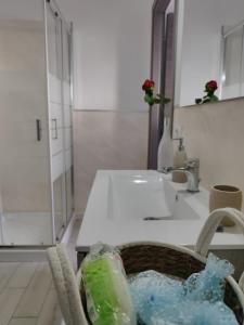 ein Badezimmer mit einem Waschbecken und einem Tisch mit einer Flasche in der Unterkunft Casa vacanze I GIRASOLI -R4042- in Sorso