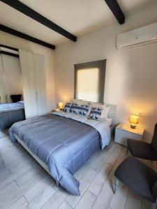 ein großes Schlafzimmer mit einem großen Bett mit blauer Bettwäsche in der Unterkunft Casa vacanze I GIRASOLI -R4042- in Sorso