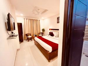 Habitación de hotel con cama y TV en Sandhya INN, en Rishīkesh