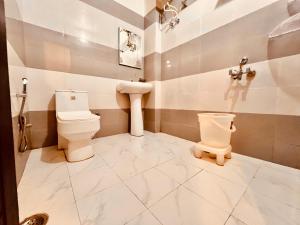 a bathroom with a toilet and a sink at Sandhya INN in Rishīkesh