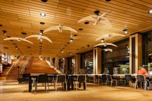 un restaurant avec des tables et des chaises et des plafonds en bois dans l'établissement Holiday Inn Express Arnhem, an IHG Hotel, à Arnhem